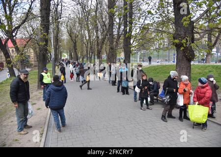 Lviv, Ucraina. 29 Apr 2021. Le persone in fila stanno aspettando la distribuzione di cibo gratuito e di set pasquali dalla comunità di mutuo aiuto 'Emmaus' a Lviv. Alla vigilia della Pasqua ortodossa, che si celebrerà il 2 maggio, la comunità di mutuo aiuto Emmaus a Lviv ha distribuito pacchetti pasquali a persone senza tetto e a basso reddito. (Foto di Pavlo Palamarchuk/SOPA Images/Sipa USA) Credit: Sipa USA/Alamy Live News Foto Stock