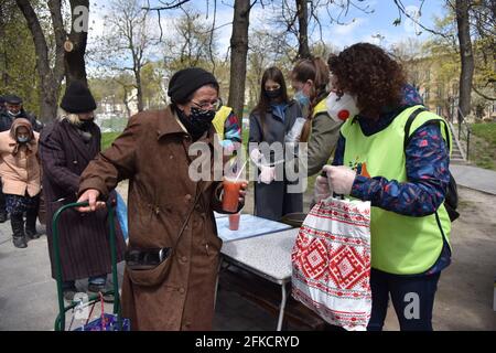 Lviv, Ucraina. 29 Apr 2021. Una donna riceve un borsch libero e un pacchetto pasquale dalla Comunità di Soccorso di Emmaus. Alla vigilia della Pasqua ortodossa, che sarà celebrata il 2 maggio, la comunità di mutuo soccorso di Emmaus a Lviv ha distribuito pacchetti pasquali ai senzatetto e alle persone a basso reddito. (Foto di Pavlo Palamarchuk/SOPA Images/Sipa USA) Credit: Sipa USA/Alamy Live News Foto Stock