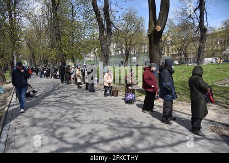 Lviv, Ucraina. 29 Apr 2021. Le persone in fila stanno aspettando la distribuzione di cibo gratuito e di set pasquali dalla comunità di mutuo aiuto 'Emmaus' a Lviv. Alla vigilia della Pasqua ortodossa, che si celebrerà il 2 maggio, la comunità di mutuo aiuto Emmaus a Lviv ha distribuito pacchetti pasquali a persone senza tetto e a basso reddito. Credit: SOPA Images Limited/Alamy Live News Foto Stock