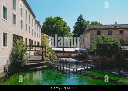 Fontaine-de-Vaucluse, Provenza-Alpi-Costa Azzurra, Francia; 25 luglio 2018: Fiume Sourge che attraversa il villaggio di Fontaine-de-Vaucluse da uno dei suoi ponte Foto Stock