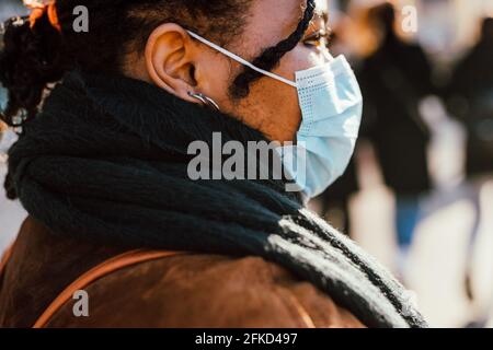 Donna che indossa la maschera al di fuori Foto Stock