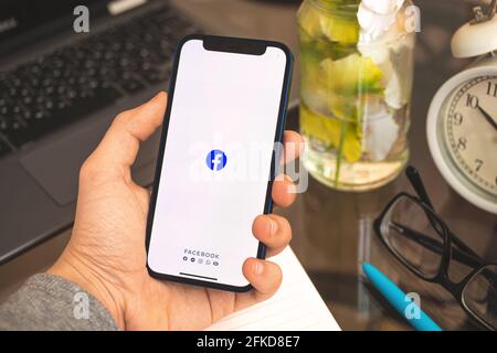 Kharkov, Ucraina - 27 aprile 2021: Il logo di Facebook sullo schermo di Apple iPhone, l'uomo usa social netwrik concetto di sfondo Foto Stock