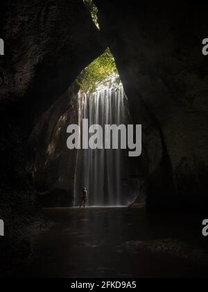 Giovane viaggiatore femminile nella foresta tropicale segreta gemma nascosta grotta canyon cascata Tukad Cepung a Bali Indonesia Sud-Est asiatico Foto Stock