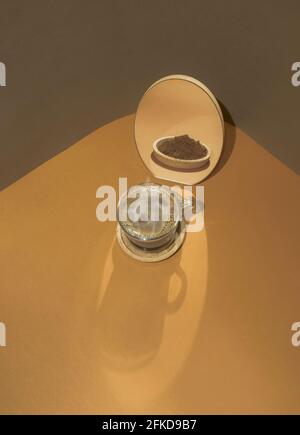 Illusione ottica di una tazza di caffè e di un caffè macinato riflesso nello specchio. Due morbidi colori di tendenza sfondo. Concetto minimo di bevande calde. Foto Stock