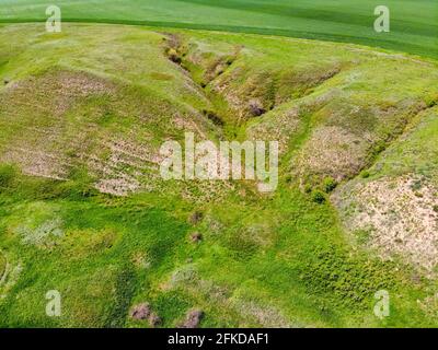 Verdi colline, campi e burroni visti dall'alto, naturale estate sfondo stagionale dal drone Foto Stock