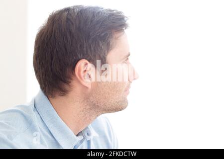 Uomo che guarda fuori della finestra Foto Stock