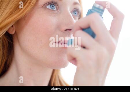 Donna che utilizza inalatore Foto Stock