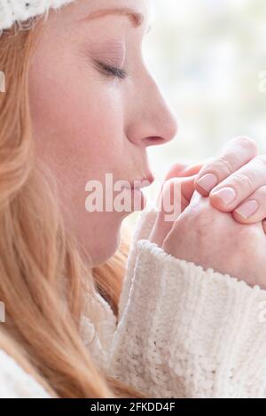 Donna riscaldando le mani Foto Stock