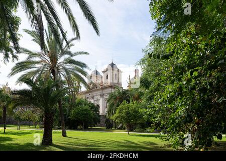 Chiesa vista attraverso alcuni grandi alberi dal vecchio fiume Turia. Valencia, Spagna Foto Stock