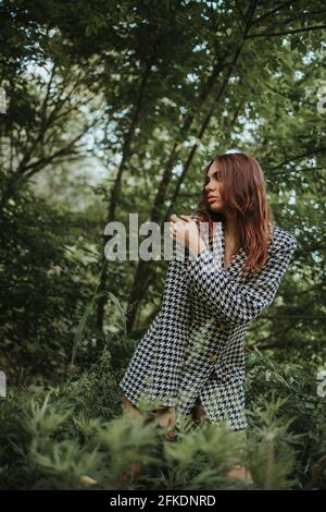 Donna caucasica in un vestito in posa nella foresta Foto Stock