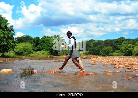 I residenti rurali del villaggio a Sane in Limpopo ancora attraversano i fiumi per ferry i bambini alla scuola a causa di problemi di carenza di infrastrutture Foto Stock