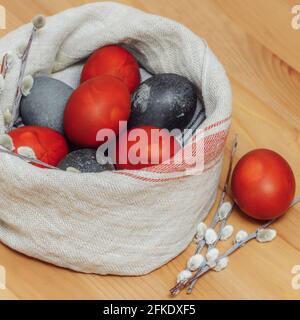 Uova di Pasqua dipinte con coloranti naturali fatti in casa e salice rami su sfondo di legno Foto Stock