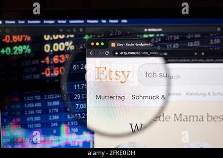 Etsy logo aziendale su un sito web con sviluppi del mercato azionario sfocato in background, visto su uno schermo del computer attraverso una lente di ingrandimento Foto Stock