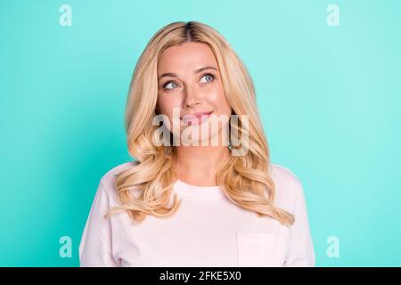 Ritratto di una donna con capelli ondulati e una mentalità allegra che pensa allo spazio di copia isolato su sfondo turchese turchese di colore teal brillante Foto Stock