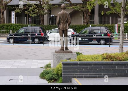 Statua del fondatore delle Olimpiadi Pierre de Coubertin al Museo Olimpico del Giappone. Sulla strada ci sono taxi con il logo Paralimpico Tokyo su di loro. (4/2021) Foto Stock