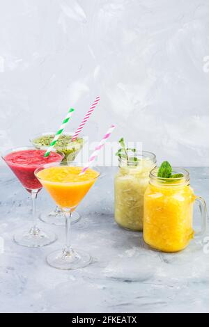 Frullato siciliano di arancia, Tangerine e kiwi servito in bicchiere martini e frullato di arancia e lime con menta in tazze di vetro cocktail analcolico Foto Stock