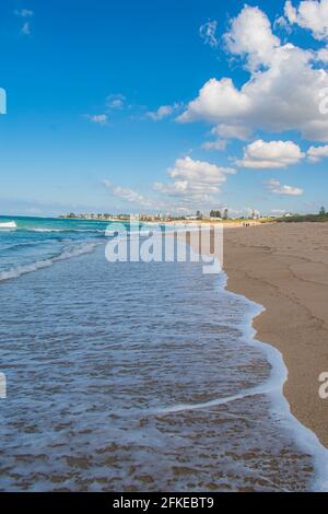 Immagine verticale di onde blu oceaniche strisciate delicatamente al riva in una giornata tranquilla Foto Stock