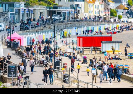 Lyme Regis, Dorset, Regno Unito. 1 maggio 2021. Regno Unito Meteo. Un inizio bello luminoso e soleggiato al fine settimana di vacanza in banca presso la località balneare di Lyme Regis. Le persone si sono recate in spiaggia per sfruttare al meglio il sole davanti alle previsioni sulle condizioni piovose e bagnate durante il fine settimana. Credit: Celia McMahon/Alamy Live News Foto Stock