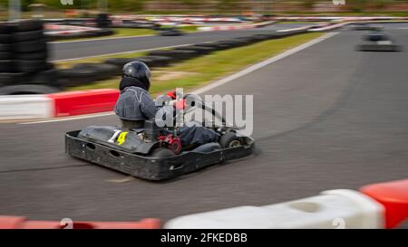 Un'immagine panoramica di un kart da corsa mentre si guida su una pista. Foto Stock