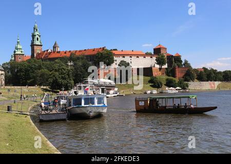 Cracovia. Cracovia. Polonia. Rive del fiume Vistola. Barche da diporto che navigano sul fiume Vistola. Wawel, il castello reale sullo sfondo. Foto Stock