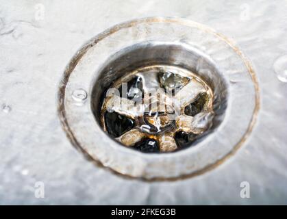 Un po' d'acqua che sgocciera UNO scarico sporco in una cucina Lavello Foto Stock