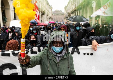 Torino, Italia. 01 maggio 2021. Un dimostratore detiene una bomba a fumo durante un raduno del giorno di maggio (noto anche come Giornata internazionale dei lavoratori o Festa del lavoro). La giornata di maggio si svolge ogni anno il 1° maggio ed è usata per segnare la lotta per i diritti dei lavoratori in tutto il mondo . Credit: Nicolò campo/Alamy Live News Foto Stock