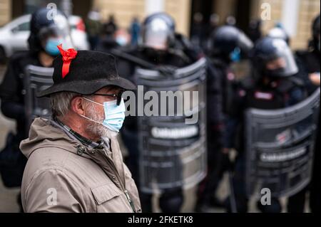 Torino, Italia. 01 maggio 2021. Un uomo che indossa il nastro rosso è visto di fronte alla polizia durante un rally del giorno di maggio (conosciuto anche come giorno internazionale dei lavoratori o Festa del lavoro). La giornata di maggio si svolge ogni anno il 1° maggio ed è usata per segnare la lotta per i diritti dei lavoratori in tutto il mondo . Credit: Nicolò campo/Alamy Live News Foto Stock