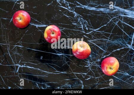 Quattro mele in fila con effetto marmorizzato nero Background - Rockit mele ancora vita - paese di origine Italia mele italiane Foto Stock