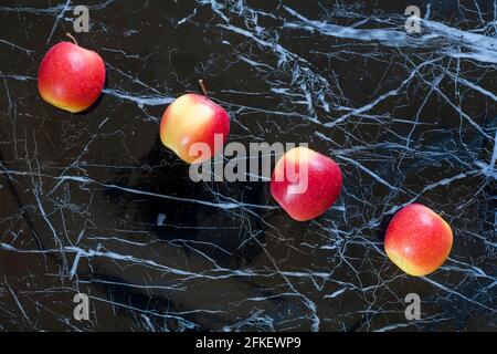 Quattro mele in fila con effetto marmorizzato nero Background - Rockit mele ancora vita - paese di origine Italia mele italiane Foto Stock