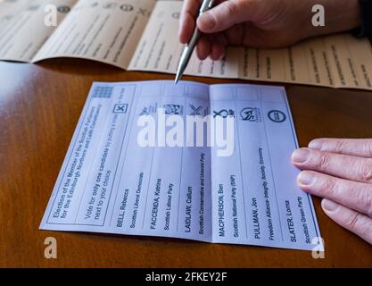 Man voting on scrutinio paper nel 2021 elezione del parlamento scozzese per la lista dei candidati regionali e del collegio elettorale di Edimburgo Nord e Leith, Scozia, Regno Unito Foto Stock