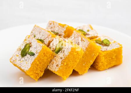 Famoso indiano Mithai Meetha Mung Daal Barfi o Moong dal Burfi Barfee fatto di farina di Gram giallo in Desi ghee misto con Mawa Pistacchio e Khoya. ISOL Foto Stock