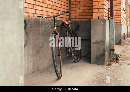 Vecchia bicicletta appoggiata alla parete dell'edificio, fuoco selettivo Foto Stock