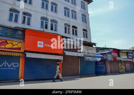 Srinagar, India. 01 Maggio 2021. Un truppe paramilitari pattugliano attraverso un mercato chiuso durante un blocco imposto dalle autorità a seguito dell'aumento dei casi di coronavirus in Srinagar.Jammu e Kashmir continuano a rimanere sotto stretto blocco il sabato a seguito dell'aumento dei casi di COVID-19. Le severe restrizioni continueranno fino al lunedì mattina. Nel frattempo, l'India ha raggiunto un nuovo record giornaliero con 4, 02,000 nuovi casi di COVID-19 e 3,521 morti nelle ultime 24 ore. (Foto di Saqib Majeed/SOPA Images/Sipa USA) Credit: Sipa USA/Alamy Live News Foto Stock