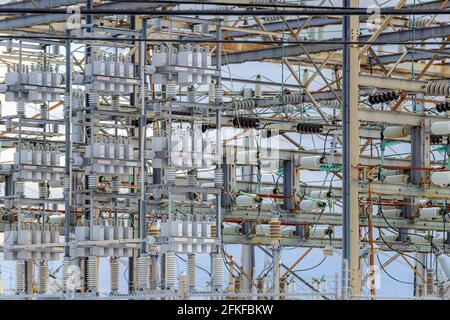 Guardando in una grande sottostazione elettrica. Molte attrezzature visibili. Profondità di campo poco profonda, messa a fuoco al centro. Foto Stock
