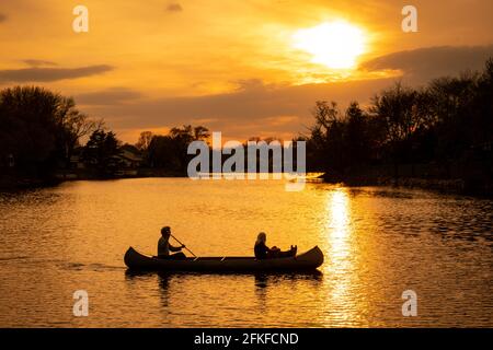 Silhouette di coppia con kayak cane nel lago a. tramonto