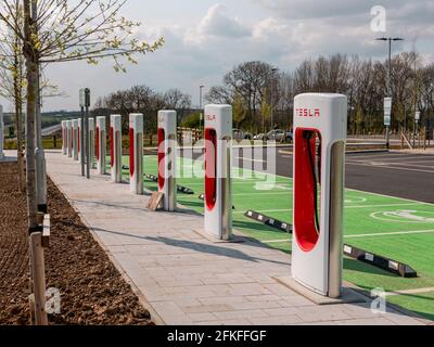 Una fila di punti di ricarica per veicoli elettrici presso Rugby Services, M6, svincolo 1. Foto Stock