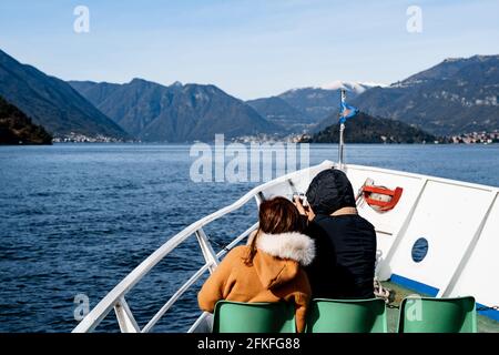 I turisti navigano su uno yacht bianco sul Lago di Como. Vista posteriore Foto Stock