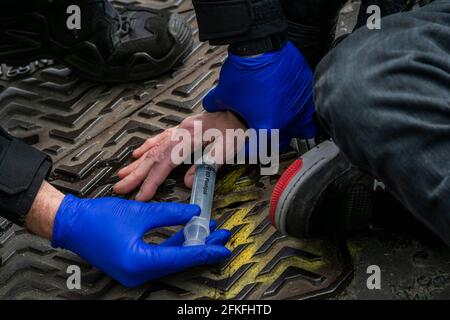 Londra, Regno Unito. 1 maggio 2021. Un uomo blocca il ponte di Westminster e si ritrova sulla strada come parte di una protesta di ribellione dell'estinzione, che è stato arrestato e rilasciato dalla colla - alle 11 del giorno di maggio (sabato 1 maggio) centinaia di persone in tutto il Regno Unito prendono provvedimenti, individualmente, In diversi luoghi disgreganti per celebrare il secondo anniversario della dichiarazione di emergenza ambientale e climatica del Parlamento nel 2019. Credit: Guy Bell/Alamy Live News Foto Stock