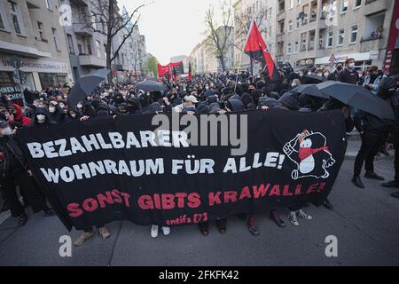 Berlino, Germania. 01 Maggio 2021. 'Alloggi accessibili per tutti! Altrimenti ci saranno rivolte!" È scritto sul banner tenuto dai partecipanti alla marcia dimostrativa dei gruppi di sinistra e di sinistra radicale sotto il motto 'dimostrazione per il rivoluzionario 1 maggio'. Credit: Michael Kappeler/dpa/Alamy Live News Foto Stock