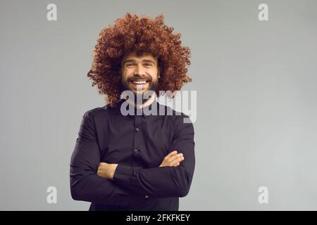 Ridendo uomo d'affari in toupee marrone curly e vestito ritratto con spazio di copia Foto Stock