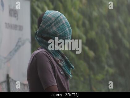 Guwahati, Assam, India. 1 maggio 2021. Un uomo copre il viso con un asciugamano durante una tempesta di polvere. Credit: David Talukdar/ZUMA Wire/Alamy Live News Foto Stock