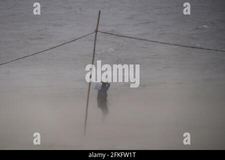 Guwahati, Assam, India. 1 maggio 2021. Un uomo che cammina sulle rive del fiume Brahmaputra durante una tempesta di polvere. Credit: David Talukdar/ZUMA Wire/Alamy Live News Foto Stock