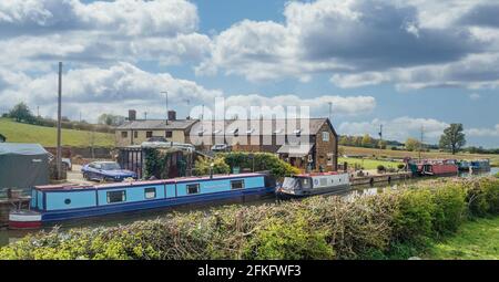 Le barche strette fiancheggiano il canale di Oxford a Twyford Wharf, Adderbury, Oxfordshire, Regno Unito. Nella foto: I locali commerciali di Twyford Wharf Narrow Boats. Foto Stock