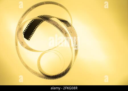 Pellicola negativa analogica in bianco e nero da 35 mm su tavolo luminoso, colore oro arancione, vista dall'alto con spazio per la copia Foto Stock