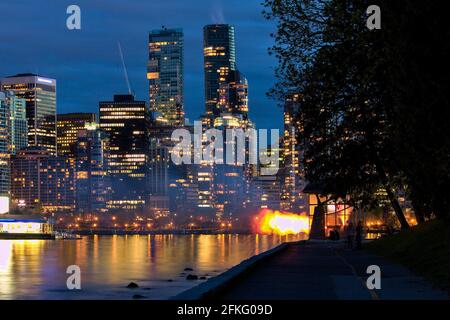 Vancouver nove o'Clock Gun sparare al buio durante l'ora blu con il paesaggio urbano sullo sfondo, Stanley Park, Vancouver, BC, Canada. Foto Stock