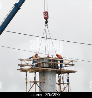 Mosca, Russia - 30 aprile 2021. Lavoratori che costruiscono un supporto ponte Foto Stock