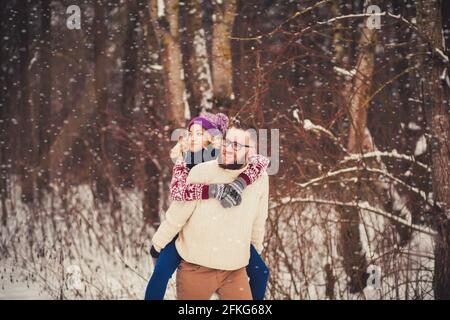 Giovane ragazzo e ragazza in winterwear godendo di nevicate. Coppia amorevole divertirsi nel fine settimana Foto Stock