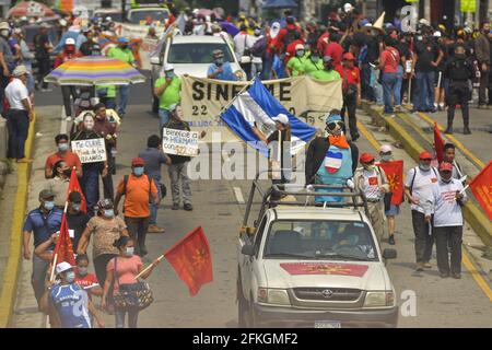 San Salvador, El Salvador. 01 Maggio 2021. I manifestanti hanno bandiere e un cartello durante la dimostrazione.i lavoratori sono scesi in piazza durante la giornata internazionale dei lavoratori in mezzo alla pandemia COVID-19. (Foto di Camilo Freedman/SOPA Images/Sipa USA) Credit: Sipa USA/Alamy Live News Foto Stock