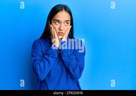 Giovane donna asiatica che indossa casual inverno maglione stanco mani che coprono viso, depressione e tristezza, sconvolto e irritato per il problema Foto Stock