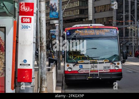 TTC (Toronto Transit Commission) bus con un segno che spiega che le maschere facciali di protezione sono Obbligatorio nel sistema di trasporto pubblico durante il Co Foto Stock